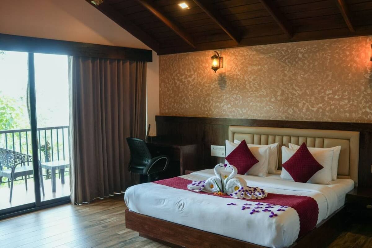 Une chambre d’hôtel avec un grand lit, un balcon et un bureau.