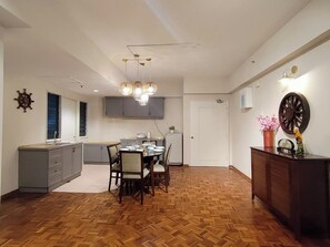 Una cocina moderna con comedor, piso de madera y un elemento decorativo en la pared.