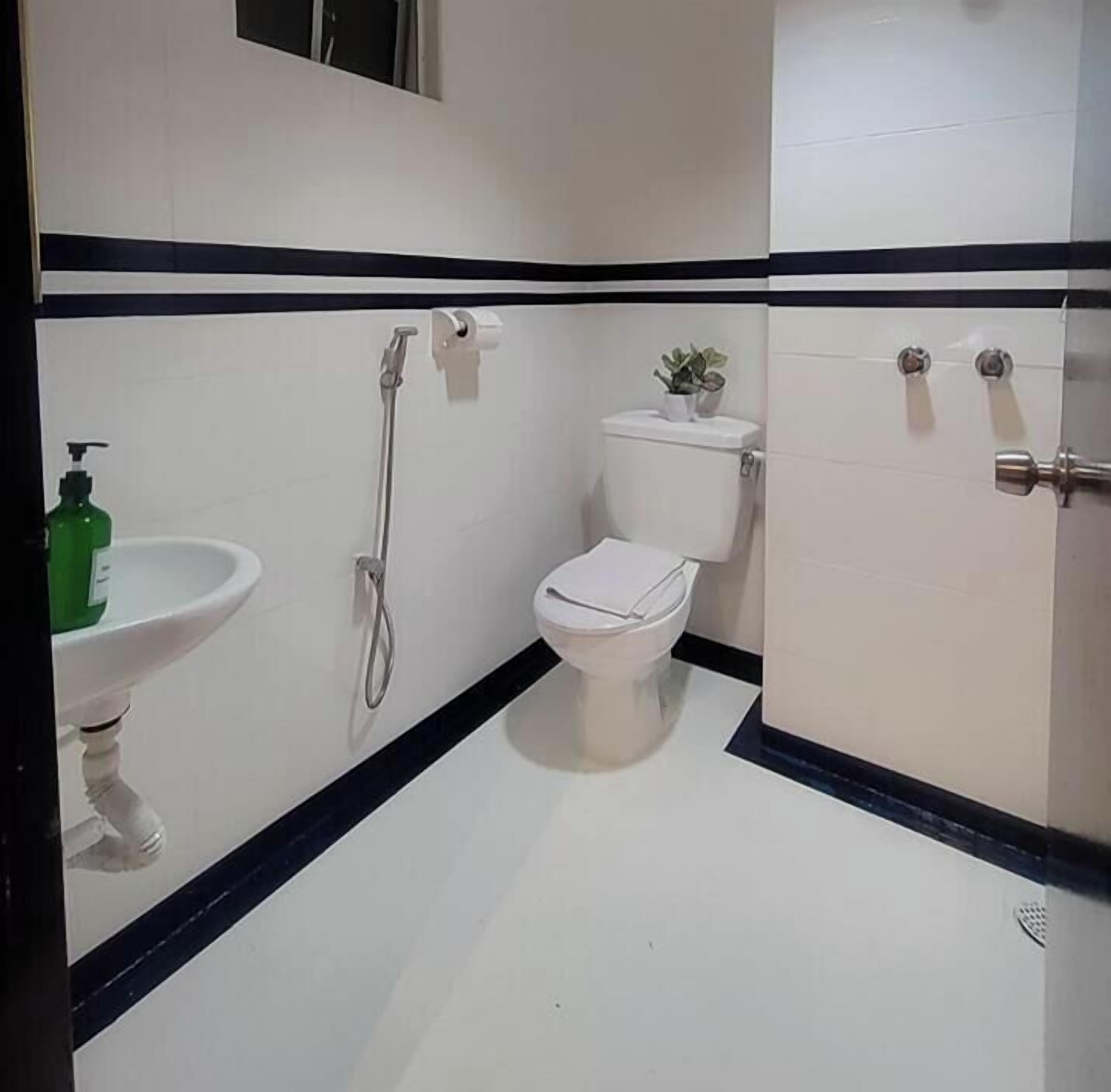 Un baño con inodoro, lavamanos y ducha.