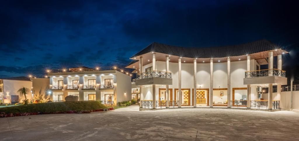 A multi-story hotel with a central courtyard, balconies, and a well-lit facade.