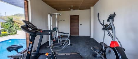 Ein modernes Fitnessstudio mit Cardiogeräten, einer Gewichtbank und einem Laufband.