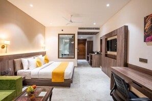 A hotel room with a bed, a desk, a TV, and a kitchenette. - Shervani Pebbles And Pine, Corbett (Ramnagar)