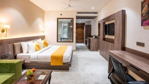 A hotel room with a bed, a desk, a TV, and a kitchenette. - Shervani Pebbles And Pine, Corbett (Ramnagar)