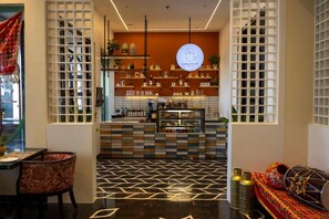 A modern interior with a bar area, patterned flooring, and a seating area with cushions. - Hotel Bawa Udaipur (Udaipur)