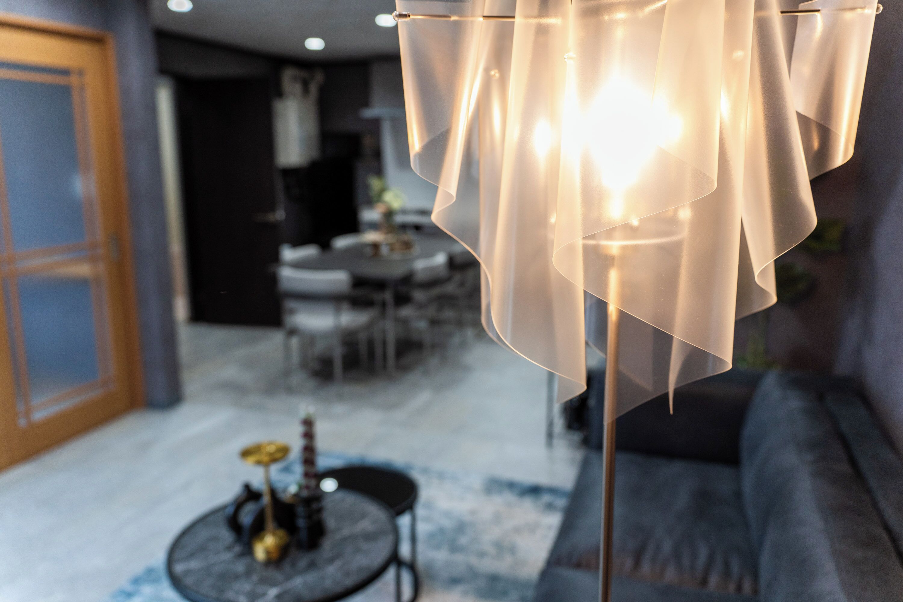 A modern living room with a sofa, a round coffee table, and a decorative lamp.