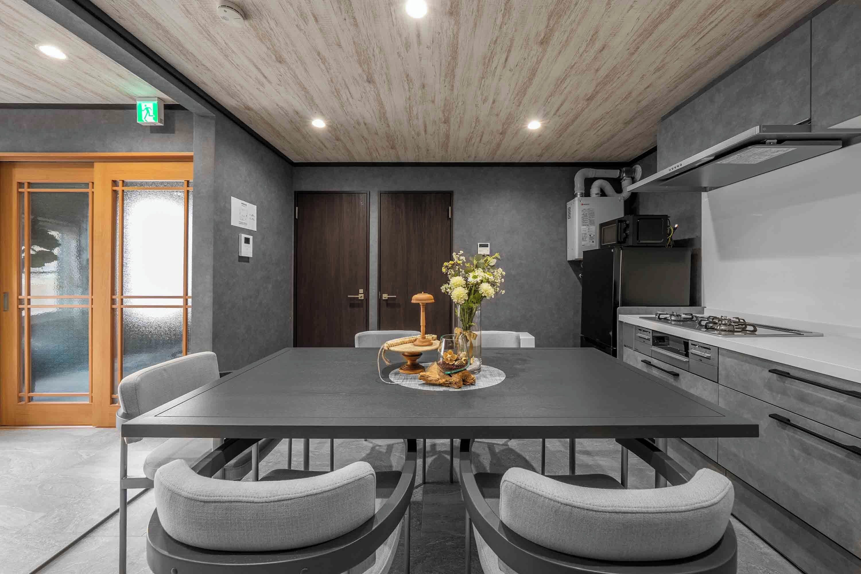 A modern kitchen with a dark countertop, a gas stove, and a microwave.
