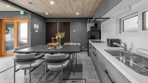 Une cuisine moderne dotée d’un îlot central, d’appareils électroménagers intégrés et d’une grande fenêtre.