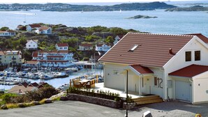 A coastal building with a red-tiled roof, situated near a marina with boats. - Panoramic view on Ellös top with 500m to sea | SE09125 (Ellös)