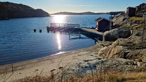 A pier extending into calm waters with a small wooden building on the right. - Panoramic view on Ellös top with 500m to sea | SE09125 (Ellös)