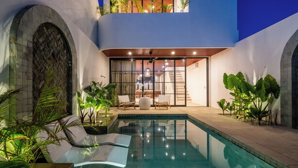 A swimming pool with lounge chairs, a covered seating area, and potted plants. - Villa Nuusa Bingin (Pecatu)