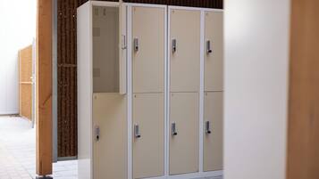 A row of beige lockers with numbered doors, each equipped with a key lock.