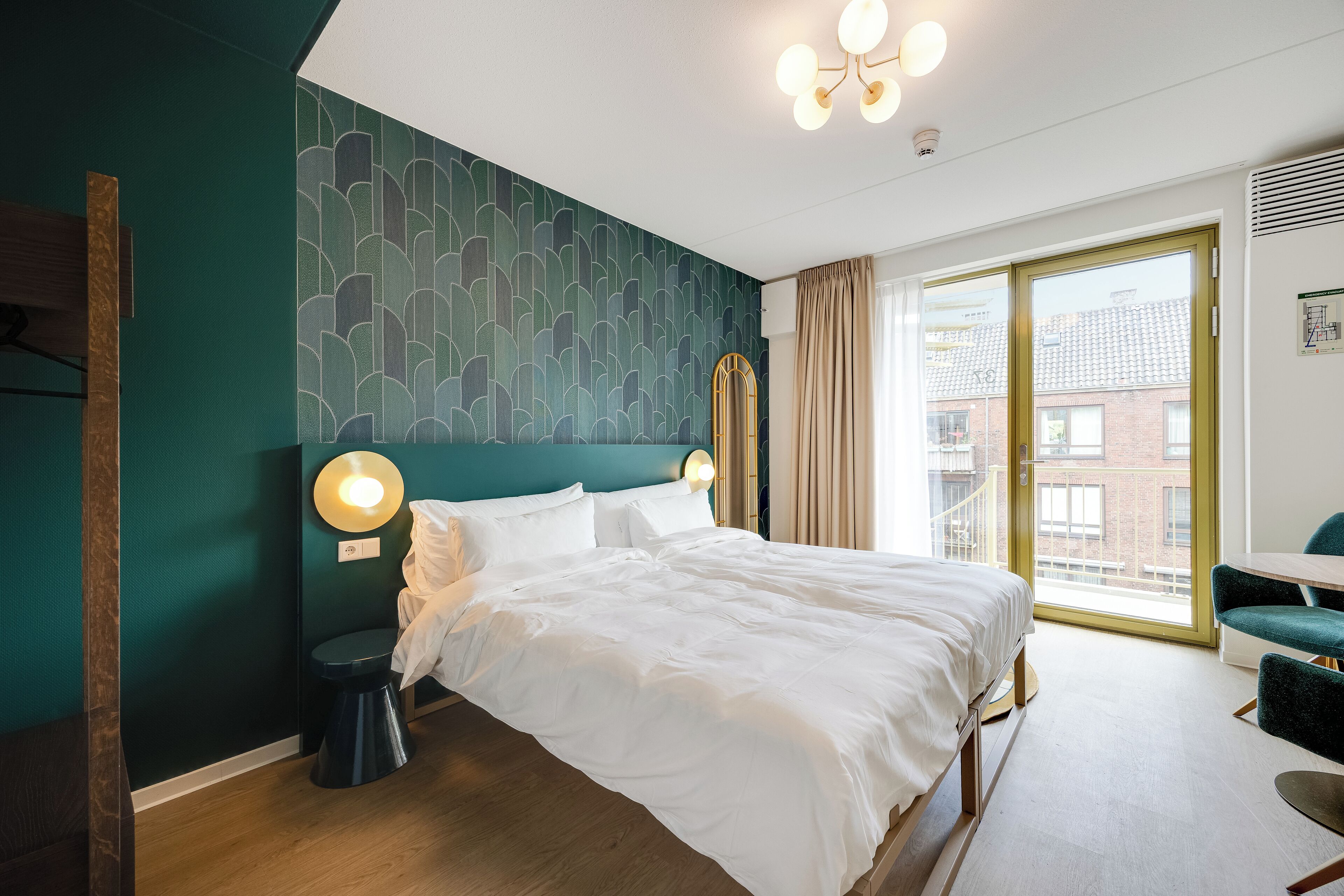 Un hotel moderno con una cama grande, un escritorio y vistas a la ciudad.