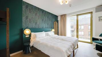 Un hotel moderno con una cama grande, un escritorio y vistas a la ciudad.