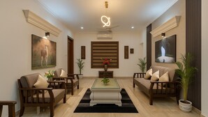 A spacious living room with a central coffee table, two sofas, and a TV on the wall. - Let'stay- Aerocity Mohali  (Mohali)