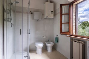 A bathroom with a glass-enclosed shower, a toilet, a bidet, and a radiator. - Oliveto Del Cantarello (Chiusi)