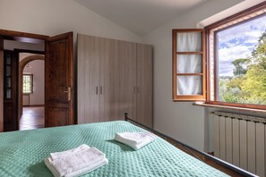 A room with a bed, a wardrobe, and a window with a view of trees. - Oliveto Del Cantarello (Chiusi)