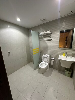 A modern bathroom with a toilet, sink, and shower area. - Manasik Al Bait Hotel Makkah (Makkah)