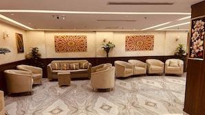 A lobby with a marble floor, beige sofas, and decorative wall art. - Manasik Al Bait Hotel Makkah (Makkah)