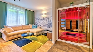 Una sala de estar moderna con un sofá color beige, una mesita redonda y una alfombra colorida.