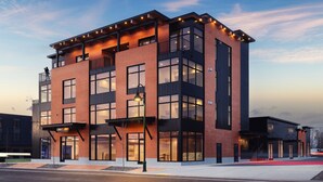 A modern multi-story building with large windows and a flat roof.