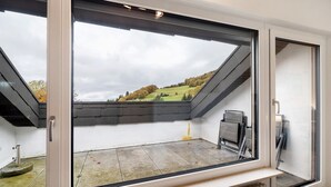 A room with a large skylight, a radiator, and a chair.
