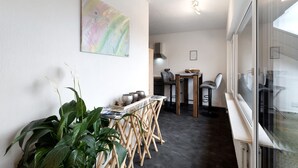 A modern interior with a dining area, a kitchen, and a large window.