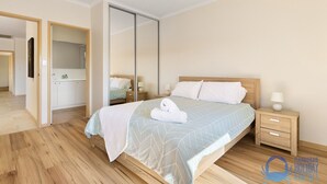 A hotel room with a large bed, a wooden nightstand, a mirror, and a wardrobe. - Canal apartment with Jetty (Halls Head)