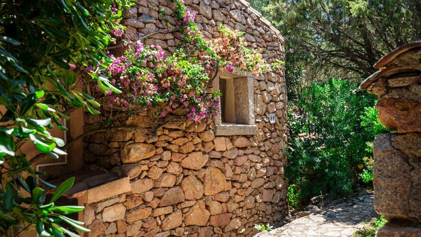 A stone building with a window and a stone wall. - Caletta Nest 88 by Klodge – Sea view & pool (Porto Rotondo)