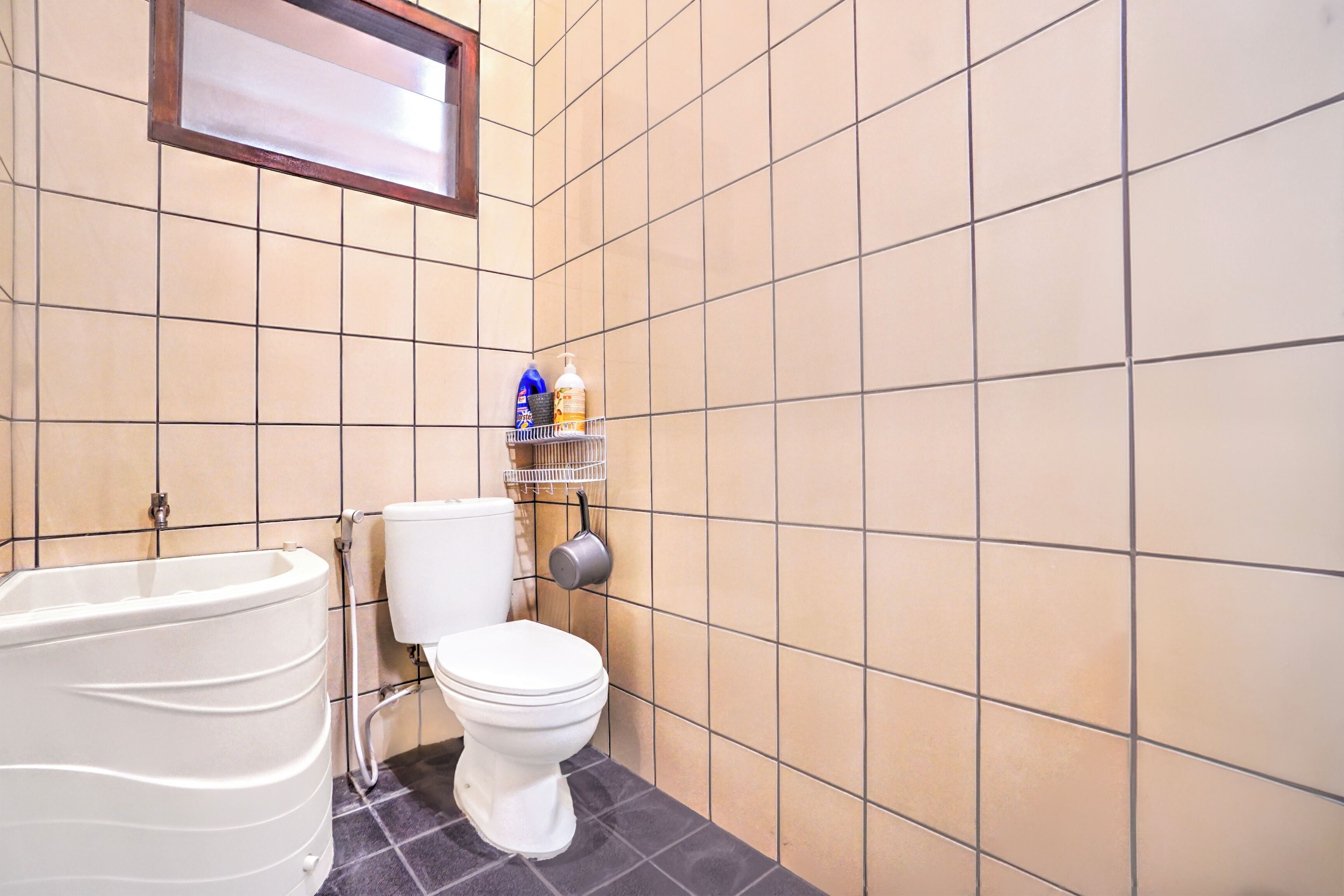 Een badkamer met een bad, toilet en betegelde wanden.