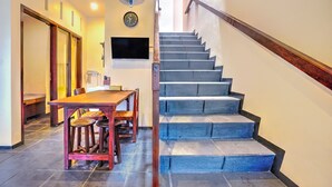Un escalier avec une rampe en bois et une horloge fixée au mur.