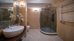 A modern bathroom with a large white sink, a glass-enclosed shower, and a toilet. - Sun & Snow VIVA MARIA SPA (Zakopane)