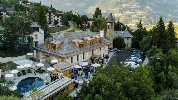 Ein Hotel mit Pool, Außenbereich und Bergblick.