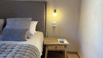 Une chambre à coucher avec un lit, une table de chevet avec une lampe, une commode et un tapis.