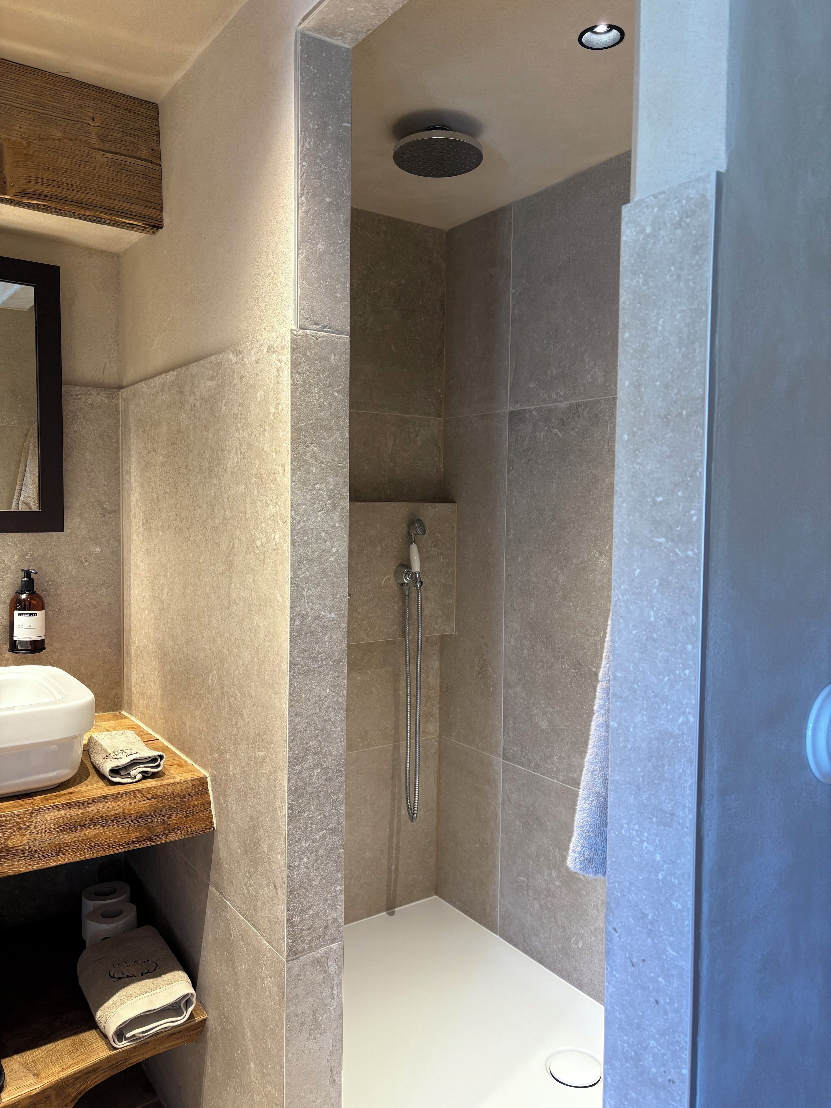 Un baño moderno con ducha, lavabo y espejo.