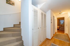 A staircase leading to a room with a bed, a window with curtains, and a small seating area. - Rüm hart - Spacious vacation apartment Rüm hart on Sylt with terrace for max. 5 persons. (Sylt-Ost)