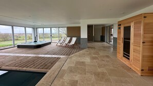 A modern spa area with a hot tub, lounge chairs, and a sauna. - Beautiful villa with indoor pool (Sainte-Cécile)