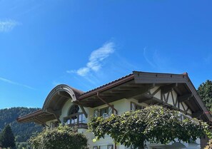 Ein zweistöckiges GebÀude mit einem gewölbten Dach und einem Balkon.