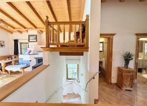 Un escalier en bois offrant une vue sur le salon et la cuisine.