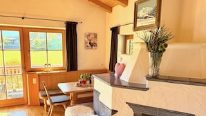 Um quarto acolhedor com lareira, móveis de madeira, um banco e uma janela com cortinas.