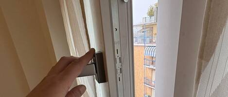 A hand operating a window latch mechanism.