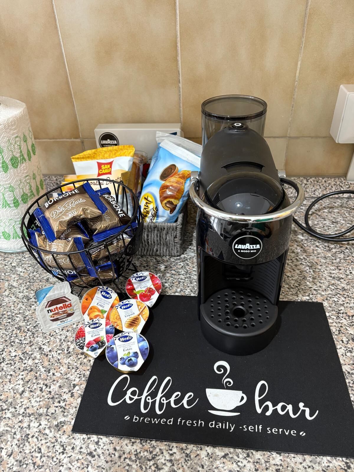Eine Küchenarbeitsplatte mit Kaffeemaschine, einer Snackkörbchen und einem Schild für die Kaffeebar.