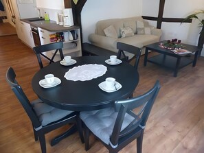 Un coin repas avec une table ronde, des chaises et une machine à café.