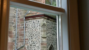 A window with a view of a stone building with a tiled roof and a small tree. - Apartment 'Pilgerzimmer' with Wi-Fi (Homberg (Efze))