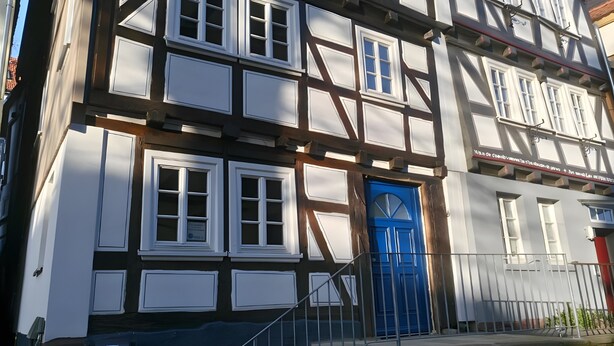 A traditional half-timbered building with a prominent blue door and multiple windows. - Apartment 'Pilgerzimmer' with Wi-Fi (Homberg (Efze))