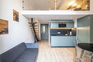 A modern interior with a staircase, a kitchen area, and a seating area.
