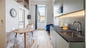 Eine moderne Küche mit Essbereich, Blick durch ein Fenster und einer Treppe.