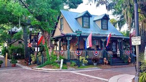 A building with a blue roof, a porch with flags, and a sign that says 'DEAD END NO THROUGH TRAFFIC.' - Oceanfront, Pool, Tennis, BBQ, Patio, Free Parking (St. Augustine)