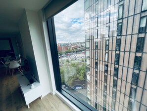 A modern room with a large window, a desk, and a chair. - City Sky View Centre Luxe Apartment - 2 Bedrooms (Manchester)