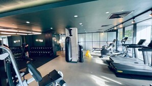 A modern gym with treadmills, elliptical machines, and weightlifting equipment.