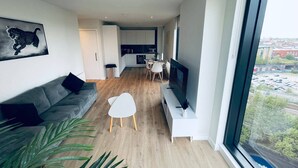 A modern apartment with a living room, dining area, and kitchen.